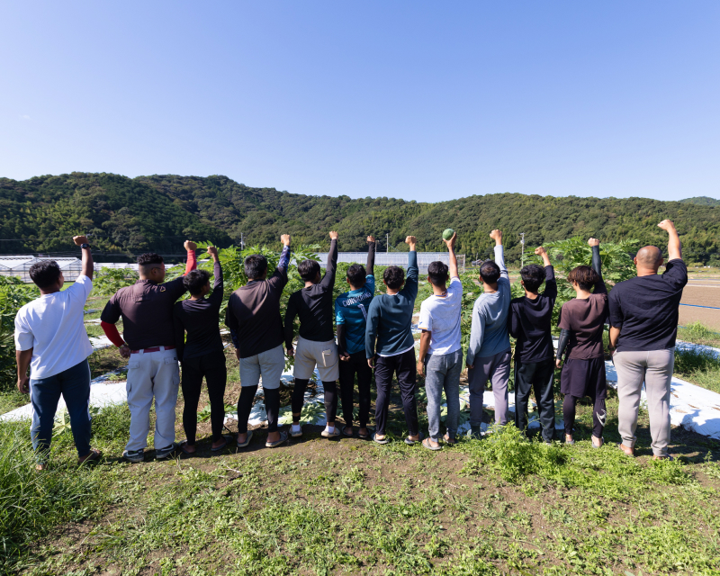 背中を向けて腕を上げる従業員写真